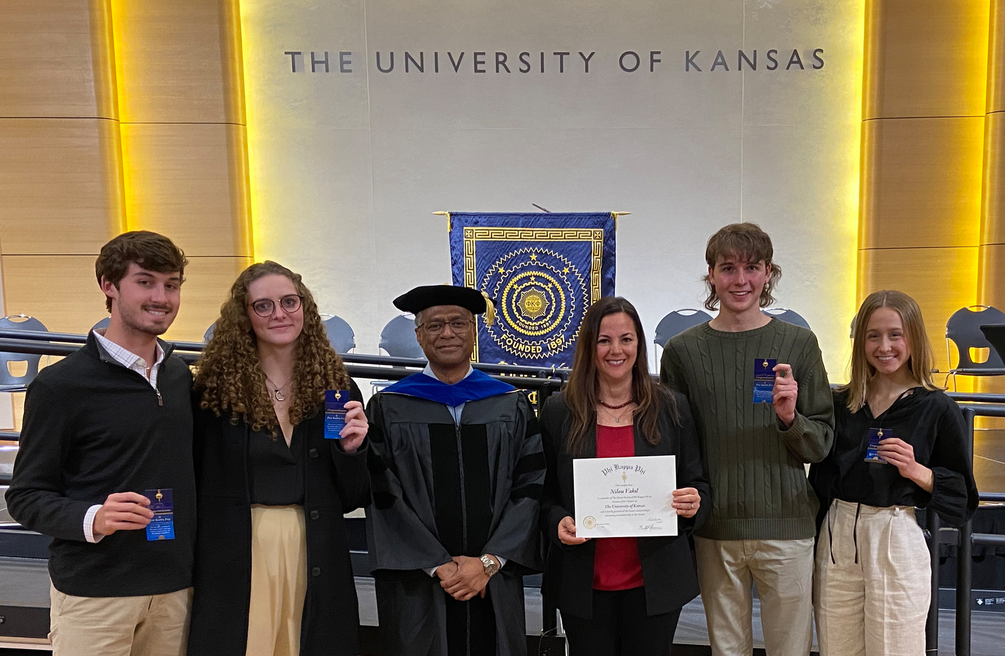 Students pose with faculty at event in ballroom at the University of Kansas.