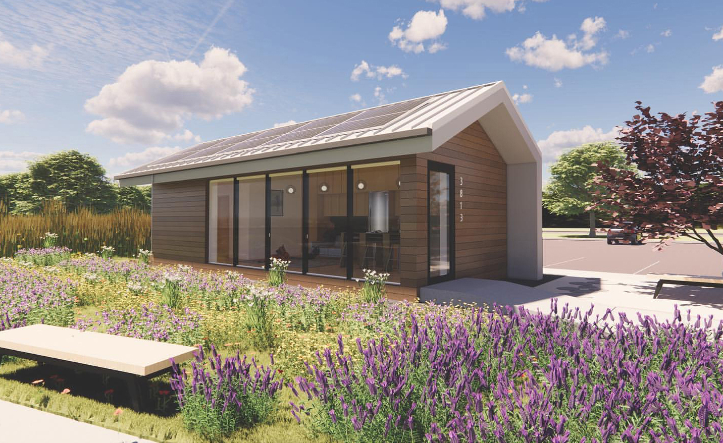 Digital rendering shows Haven Studio, a small wood-clad home with photovoltaic panels on roof, sited in a landscape of prairie plants in full bloom.