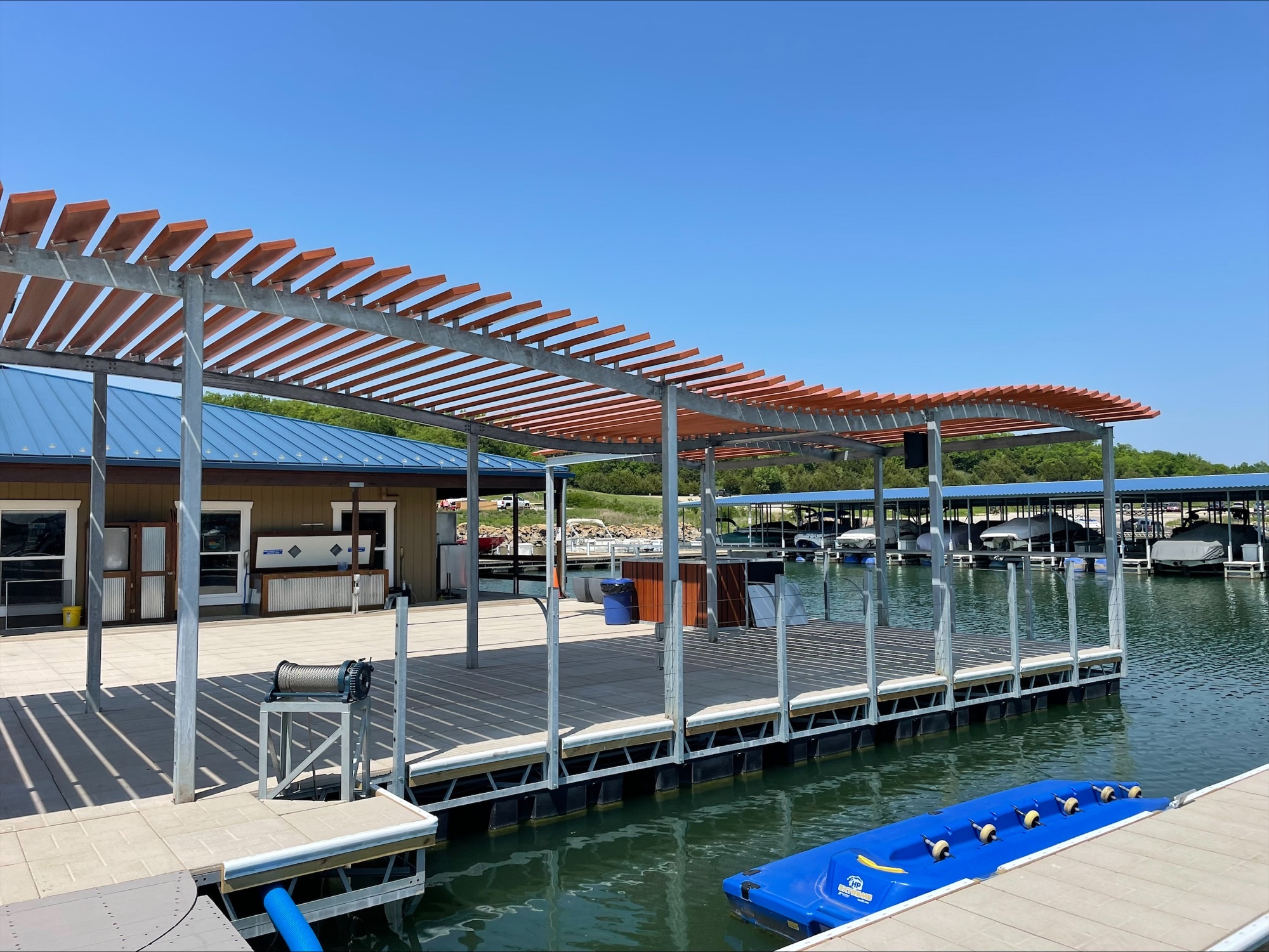 Color photograph of a steel and wood shade structure built atop floated wood deck.