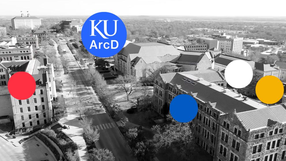 black and white aerial photograph of University of Kansas campus. Blue circle holds text that says 'KU ArcD'. Red, blue, white, and yellow circles identify ArcD buildings.